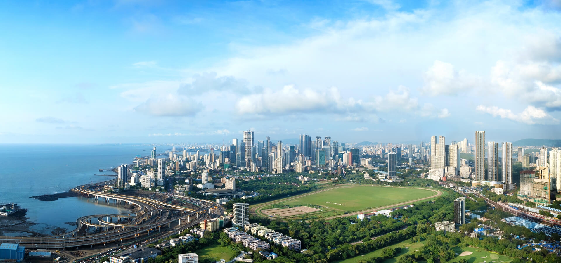 Panoramic view across Mahalaxmi Racecourse towards the Mumbai coastline and skyline.